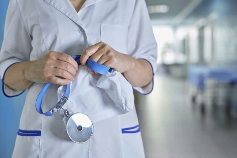 Mâinile unul doctor ORL având în background holurile unui spital